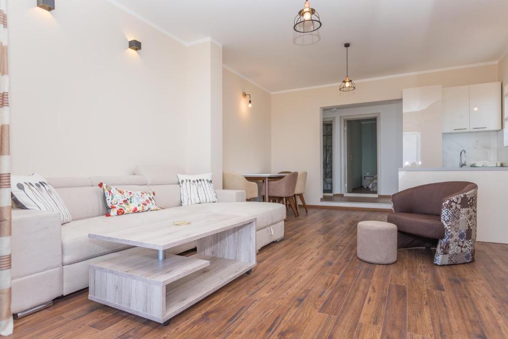 a living room with a white couch and a table at apartman 2 in Budva