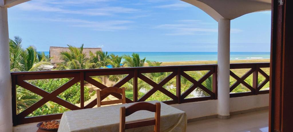 balcón con mesa y vistas al océano en Guesthouse Bambou Beach en Grand-Popo