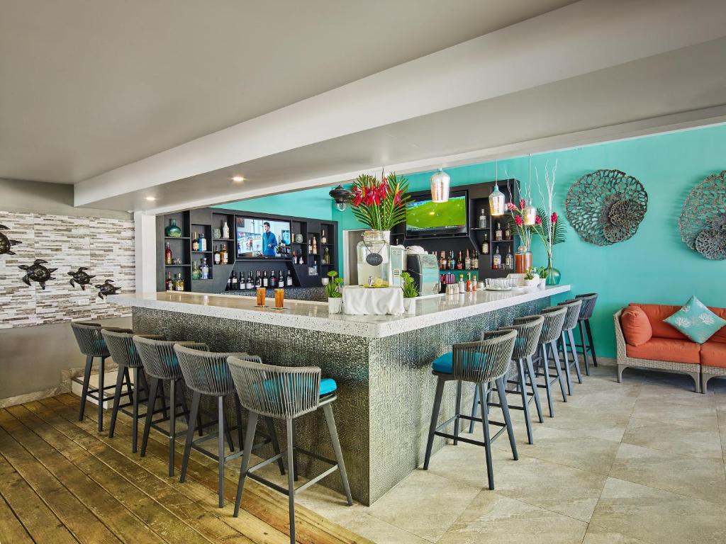 a bar in a restaurant with a red couch at Coconut Court Beach Hotel in Bridgetown