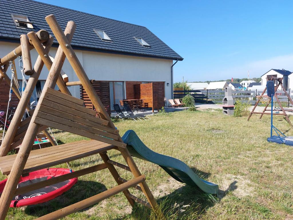 plac zabaw z drewnianym krzesłem i zjeżdżalnią w obiekcie Lazurowe Domki Jastrzębia Góra w Jastrzębiej Górze