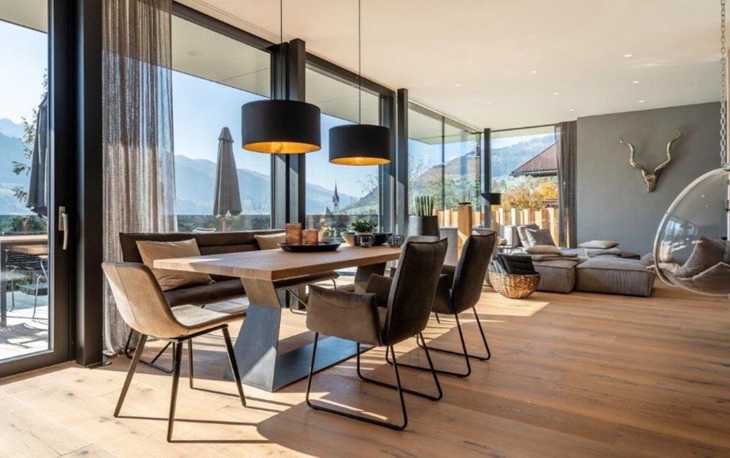 Luxus Design Chalet Sonnrain في بيسندورف: غرفة طعام مع طاولة وبعض الكراسي