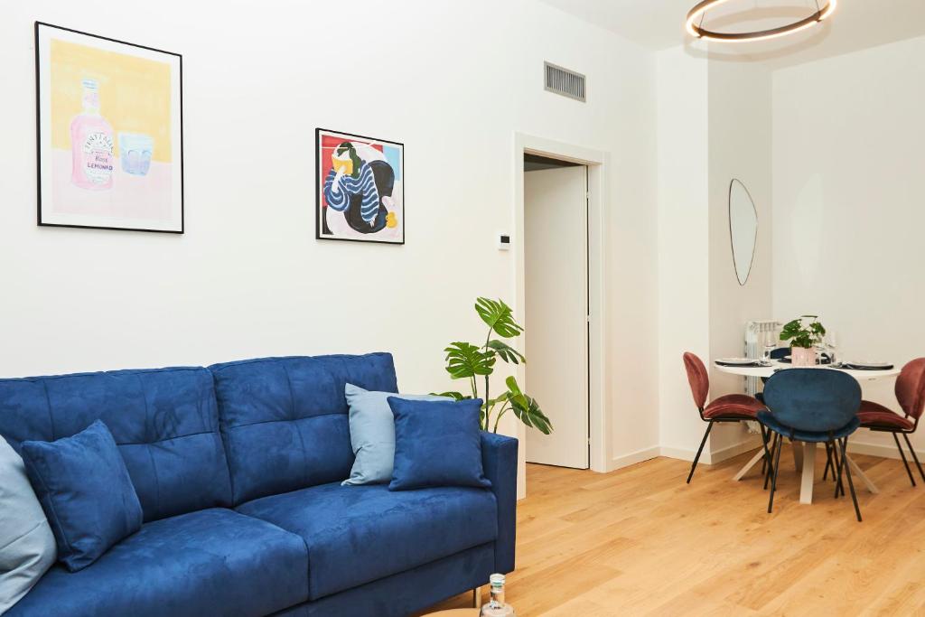 a living room with a blue couch and a table at MILANO URBAN FLATS Modern apartments few minuts from Duomo in Milan