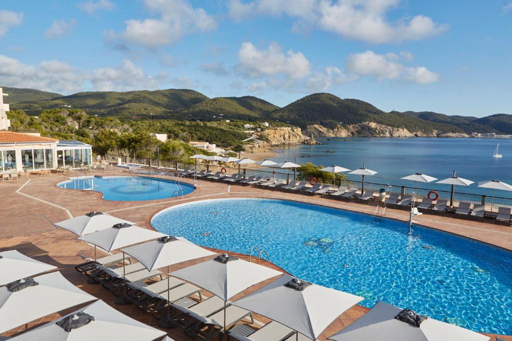 a resort with a pool and a view of the ocean at Invisa Hotel Club Cala Verde in Es Figueral Beach