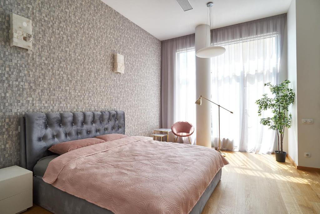 um quarto com uma cama e uma grande janela em Alexander apartment em Riga