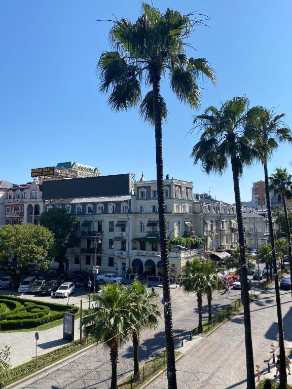 un gruppo di palme davanti a un edificio di Rustaveli Ave Apartment a Batumi