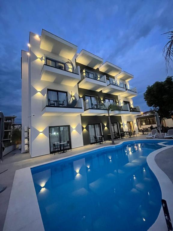 a villa with a swimming pool in front of a building at Absolute Hotel Ksamil in Ksamil