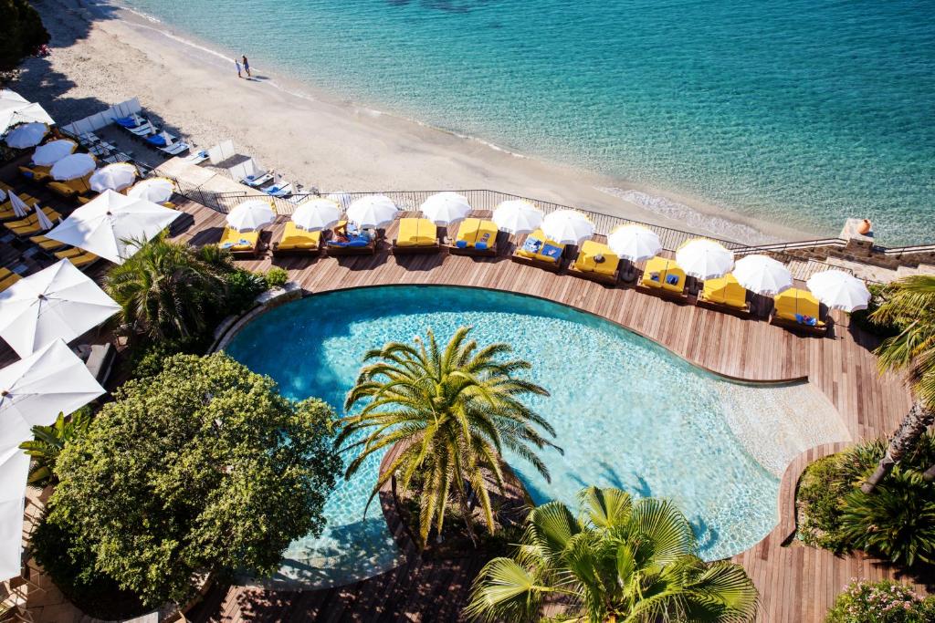 een luchtzicht op een resort met een zwembad en het strand bij Hôtel Le Bailli De Suffren in Rayol-Canadel-sur-Mer
