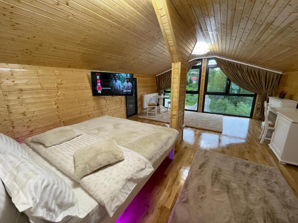 ein Schlafzimmer mit einem großen Bett und einem Flachbild-TV in der Unterkunft Pensiunea AlexOlar New One in Arada