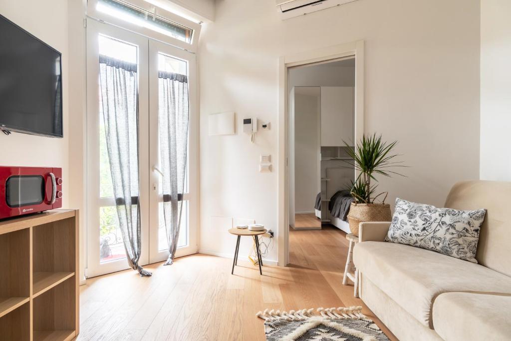 ミラノにあるLa casa sull'albero Navigliのソファとテレビのあるリビングルーム
