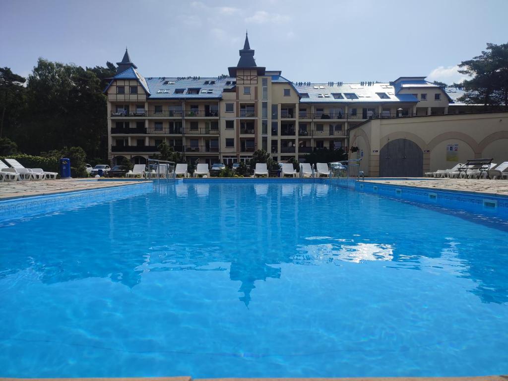 a large blue swimming pool in front of a building at Apartament 101 Blue Mare in Łukęcin