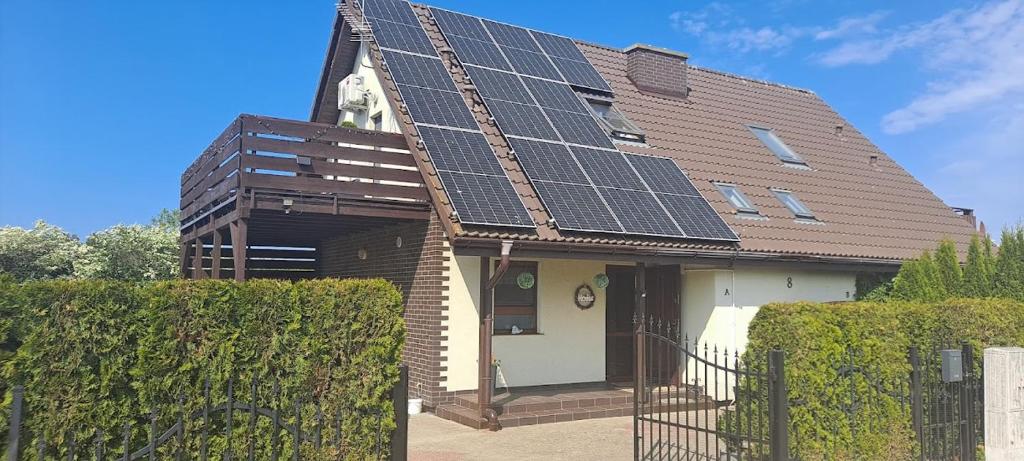 uma casa com painéis solares no telhado em DOMEK-NADMORSKI ZAKĄTEK em Pogorzelica