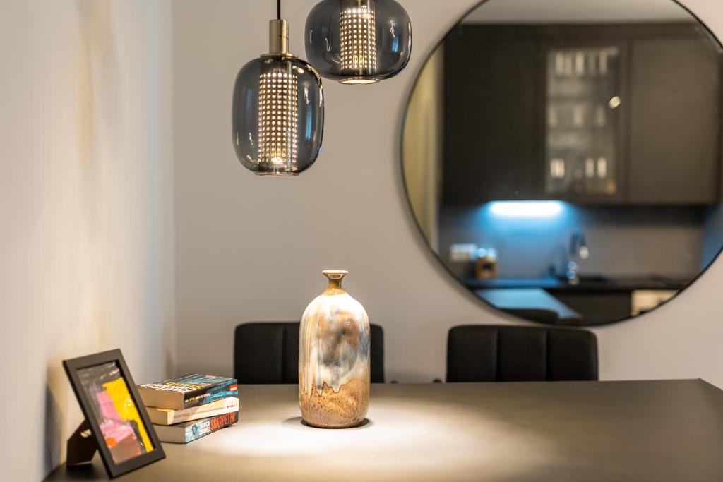 a vase sitting on a table in front of a mirror at Flaka's Apartment in Vienna