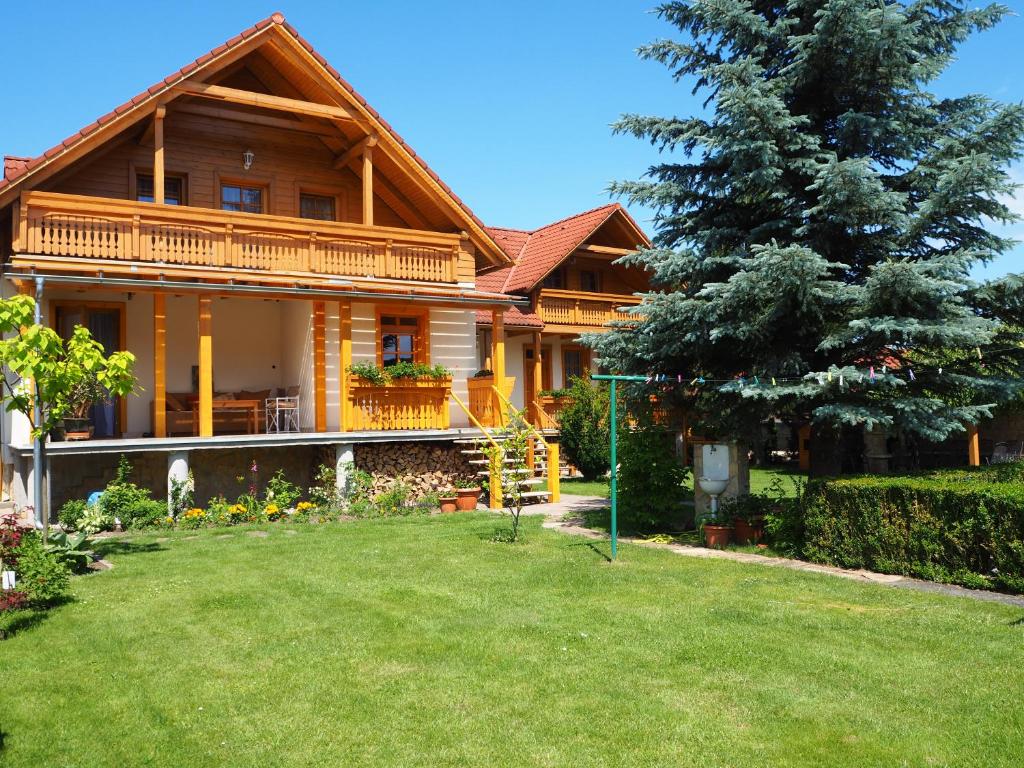 a large wooden house with a green yard at Privat Alenka in Liptovský Mikuláš