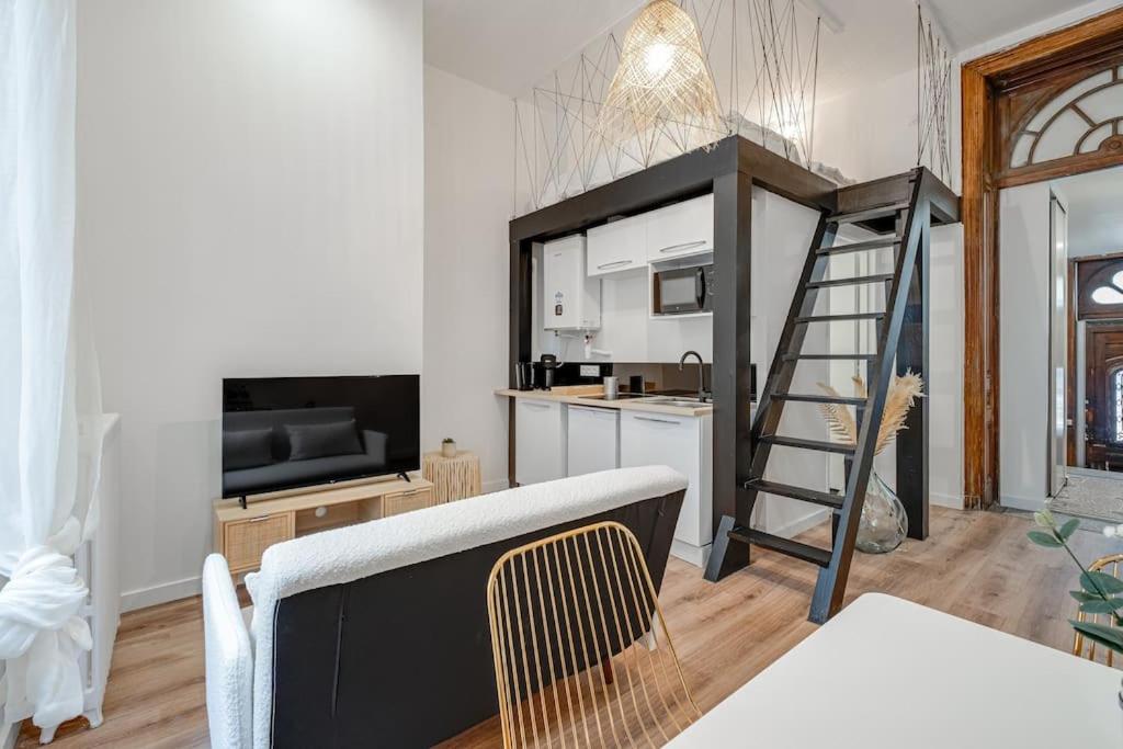 a living room with a kitchen and a stair case at  Le Bohème superbe Loft fonctionnel et central in Saint-Étienne