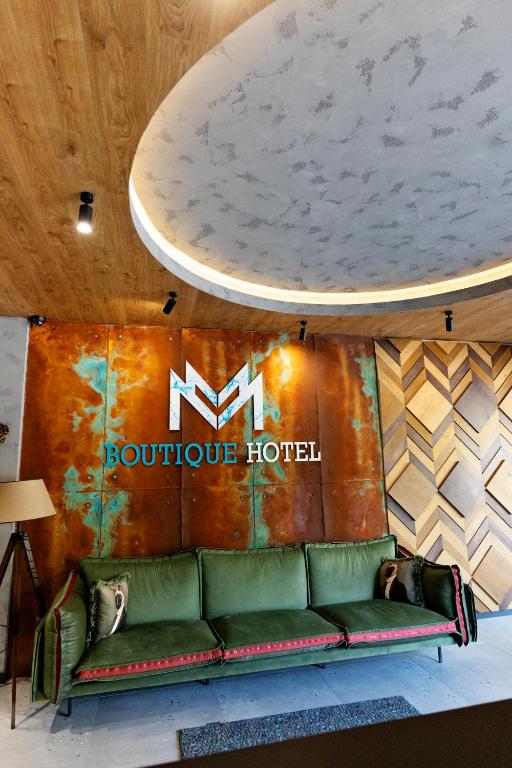 a couch in front of a booth at a hotel at MM Boutique Hotel in Burgas
