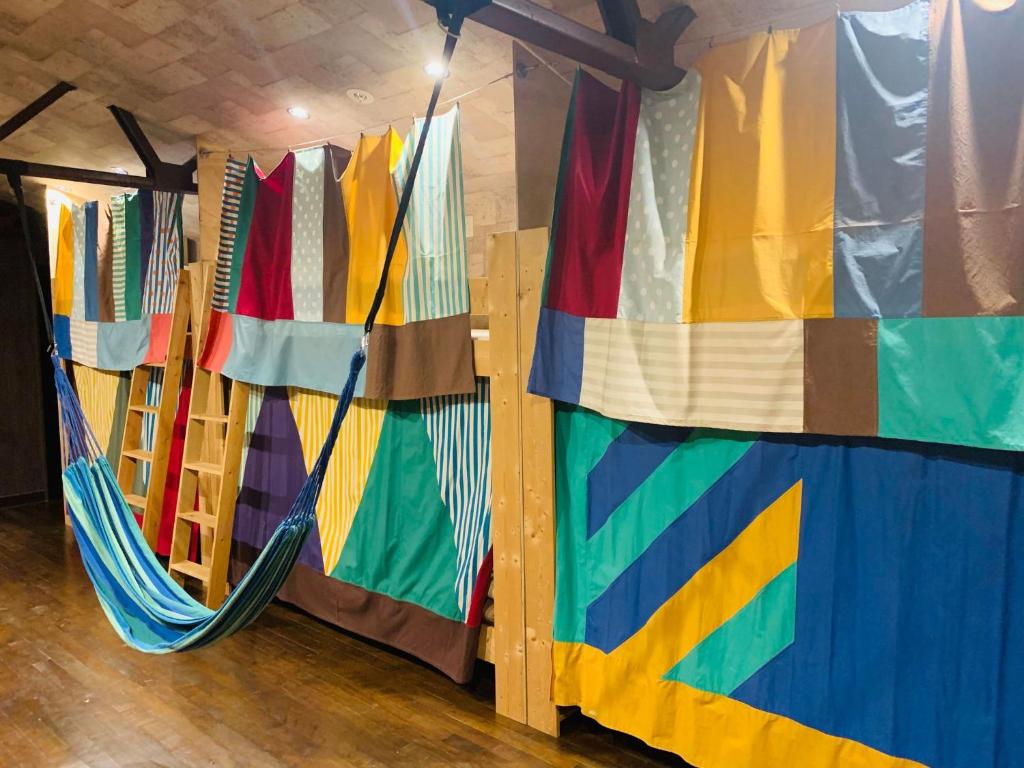 a room with colorful curtains and a hammock at Omotenashi LAB in Sakura