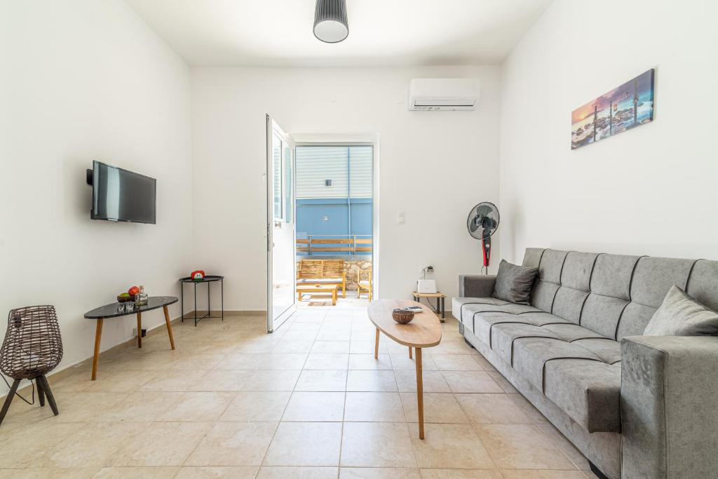 a living room with a couch and a table at BeachFront Apt next to the Mall in Heraklio