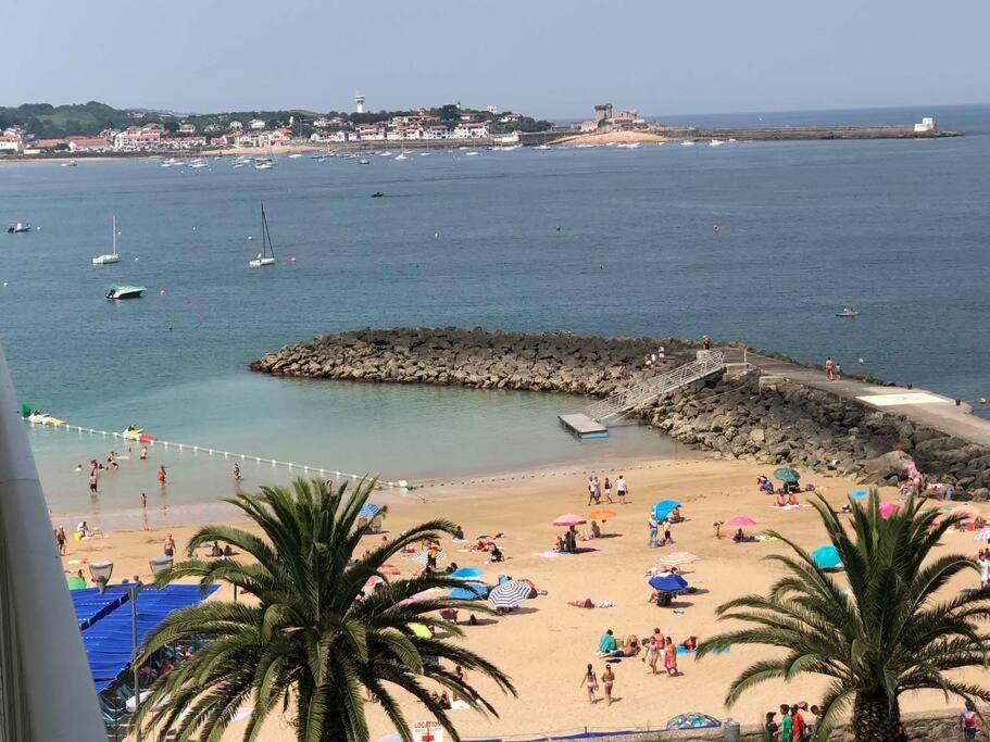 un groupe de personnes sur une plage près de l'eau dans l'établissement Spacieux appartement vue Océan et Rhune, à Saint-Jean-de-Luz