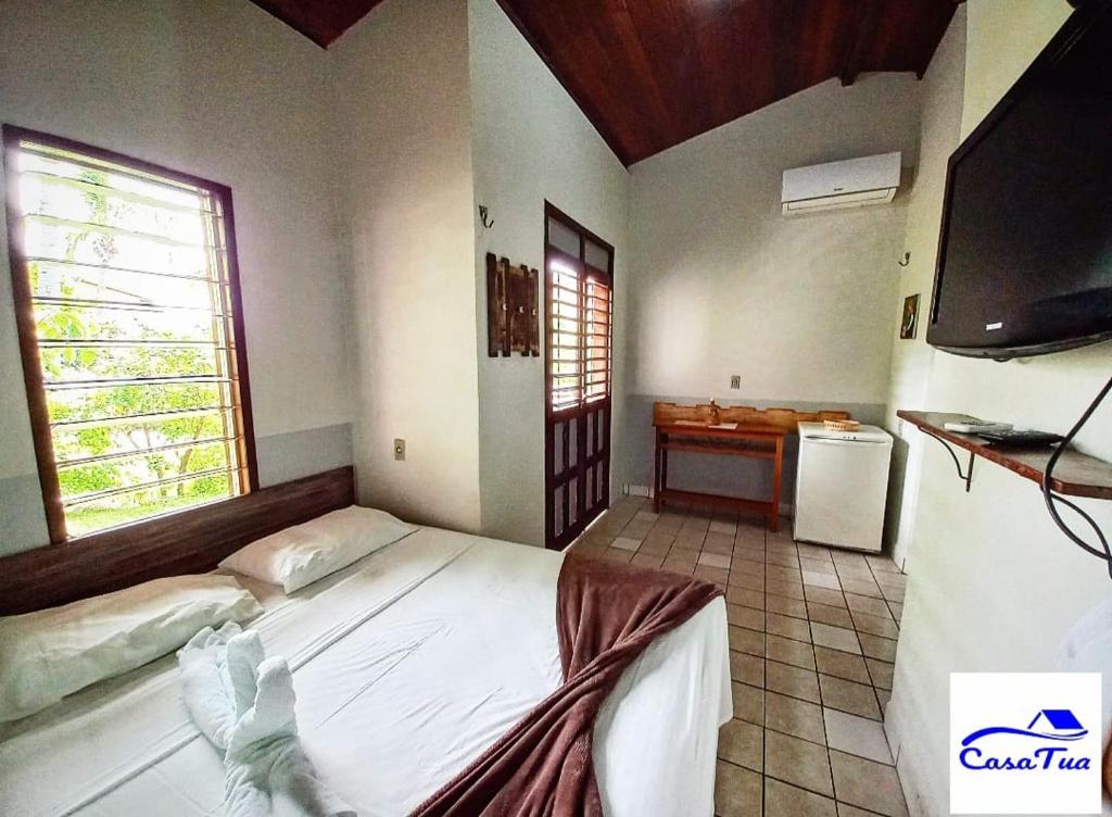 1 dormitorio con 1 cama y TV de pantalla plana en Casa Tua Pipa en Pipa