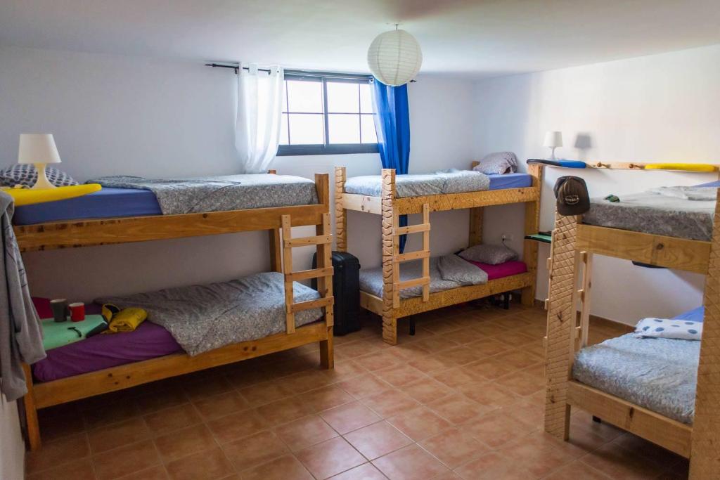 a room with four bunk beds in it at Long Beach Surf House in Corralejo