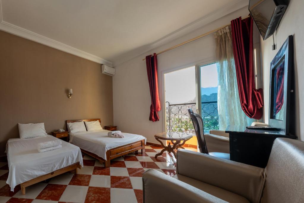 a hotel room with two beds and a window at Hotel Saint Antoine in Tafraoute