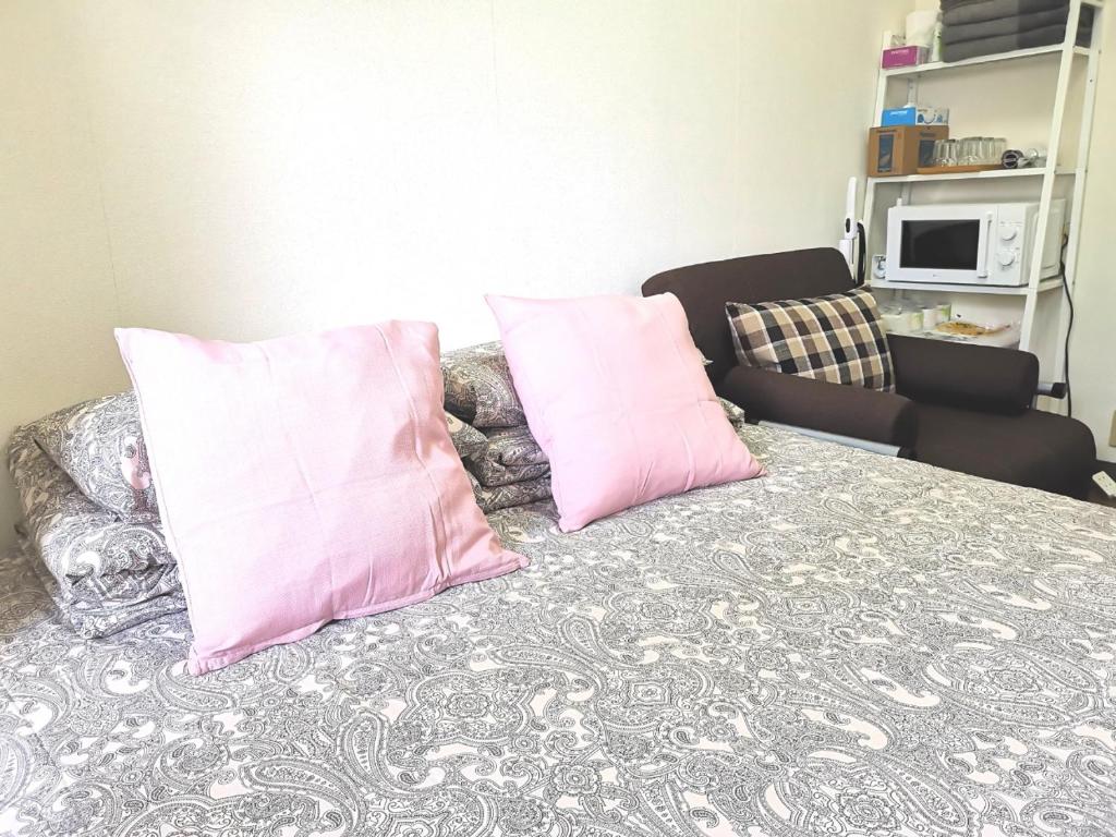 2 almohadas rosas encima de la cama en DP House, en Tokio