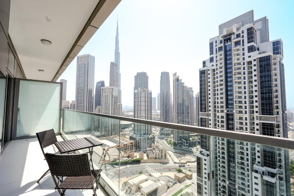 a balcony with two chairs and a view of a city at Luxury Apartment burj khalifa view in Dubai