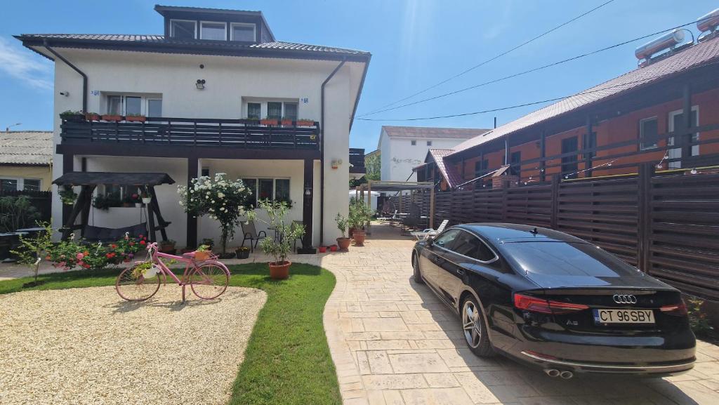 ein schwarzes Auto, das vor einem Haus parkt in der Unterkunft Casa Sebastian in Costinești