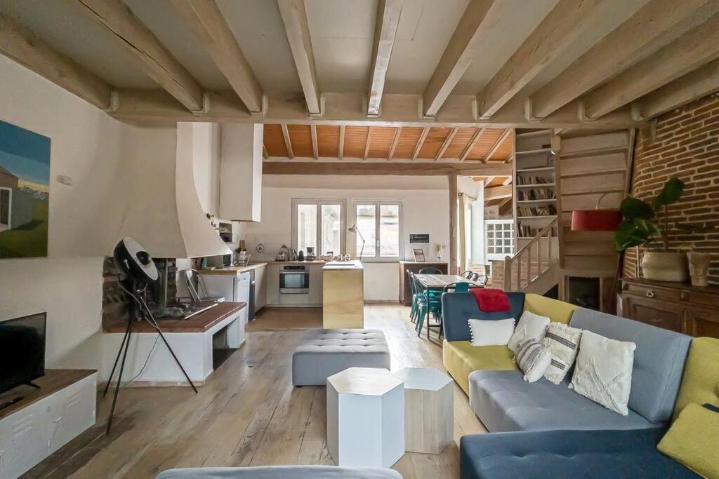 ein Wohnzimmer mit einem blauen Sofa und einer Küche in der Unterkunft NOCNOC - L'Artiste du Capitole, hyper-centre, 4 lits in Toulouse