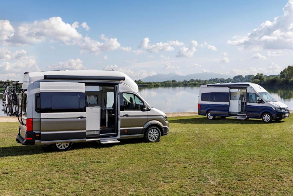 dos caravanas estacionadas en un campo junto a un lago en Campervan Rental Dublin - VW Grand California en Dublín