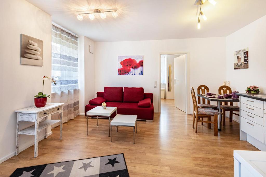 a living room with a red couch and a table at Ferienwohnung Am Bach in Rheinfelden