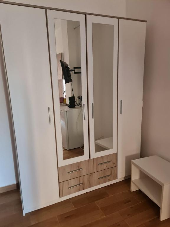 a white cabinet with a mirror in a room at Apartman K2 in Kraljevo
