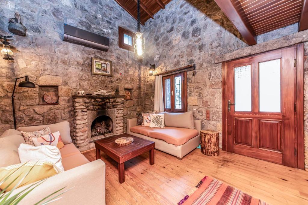 a living room with a stone wall at Chic Villa w Fireplace 3 min to Beach in Bodrum in Bitez