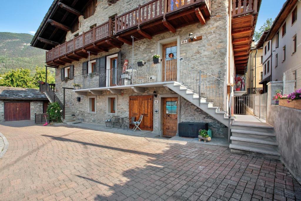 a stone building with a staircase and a balcony at Souvenir au Moulin in Aymavilles
