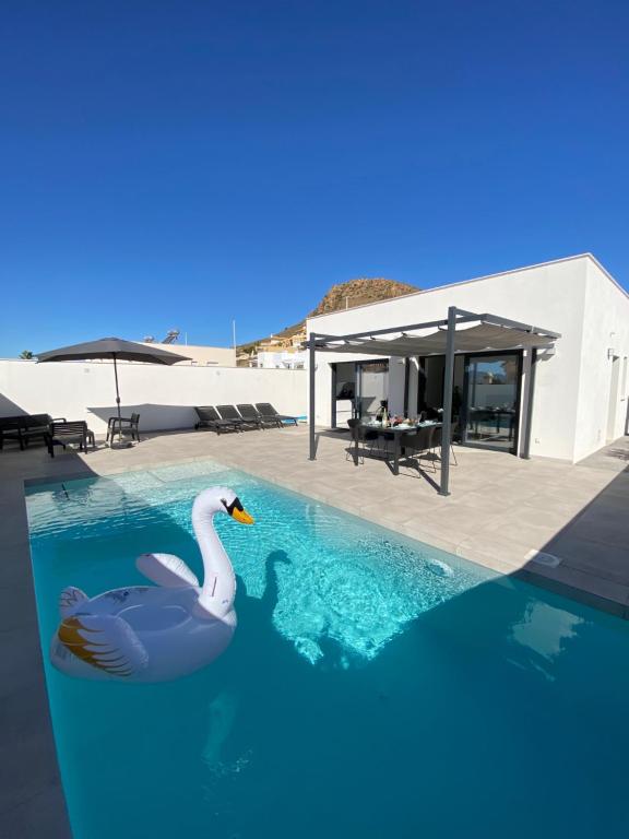 a swimming pool with a swan in the water at Villa Demi-Adore in Mazarrón