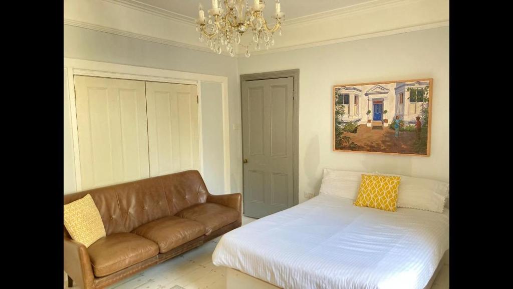 uma sala de estar com um sofá e uma cama em Central Truro! Large Double Room In Victorian Property em Truro