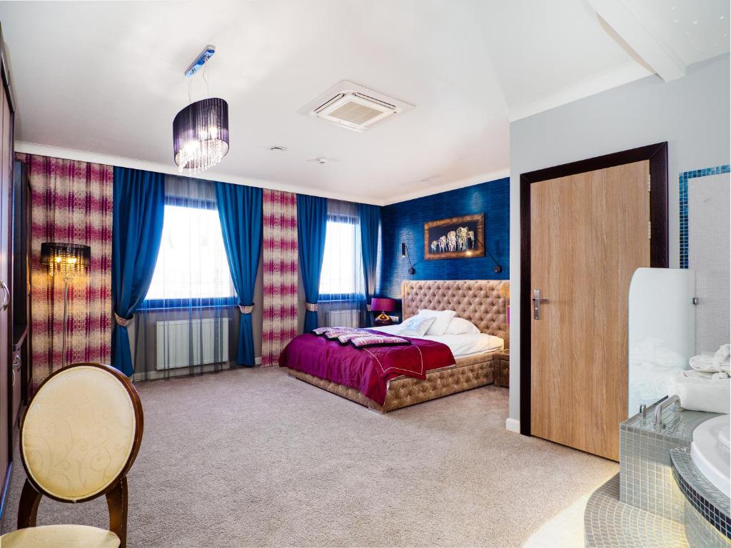 Schlafzimmer mit einem Bett und blauen Wänden in der Unterkunft Resort Strzelnica in Kochcice