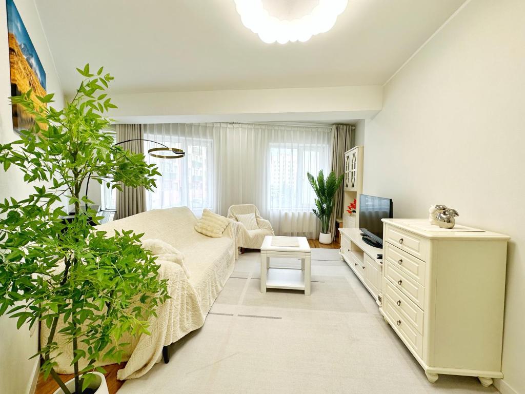 1 dormitorio con 1 cama, TV y plantas en 135m2 new apartment 5 rooms with airport pickup, en Ulán Bator