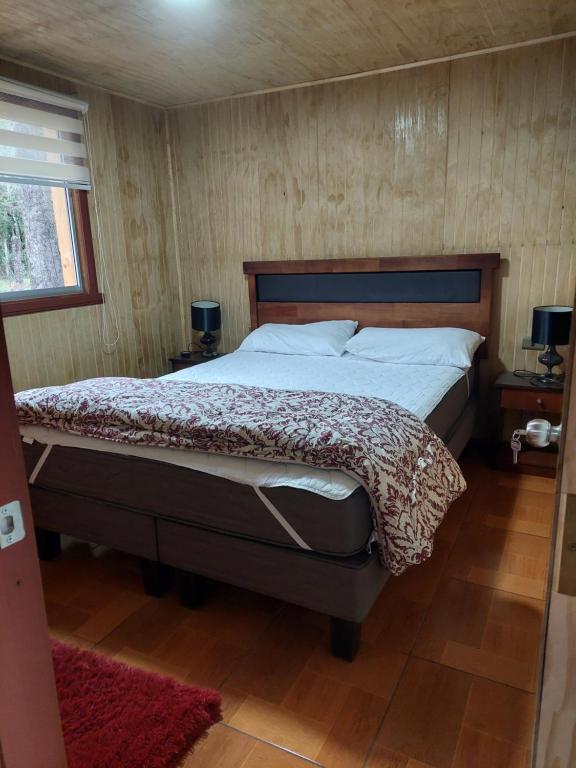 a bedroom with a large bed in a room at Cabaña Mirador Del Cautín in Curacautín