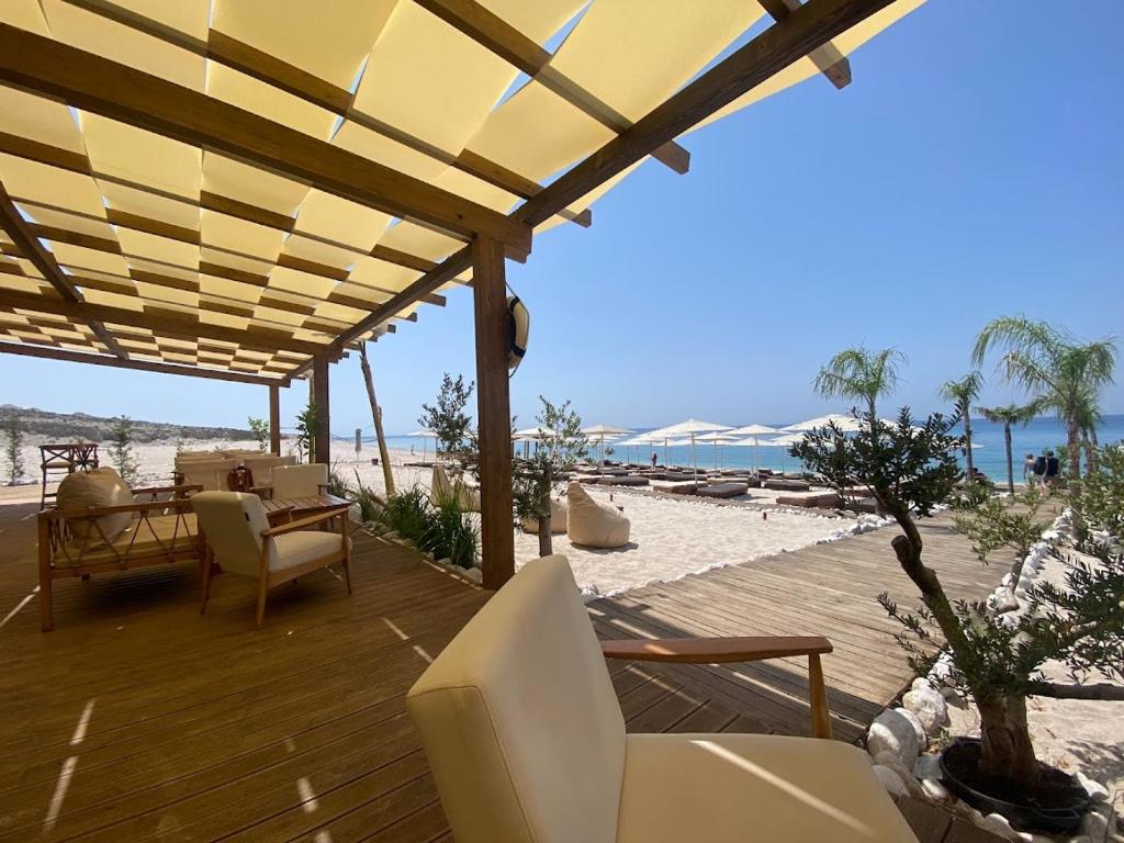 a wooden deck with chairs and a view of the beach at Le bellevue apartment in Llogara