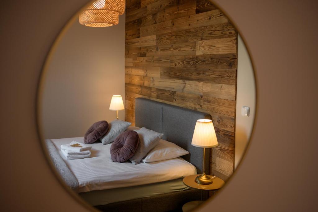 a bedroom with a bed with a mirror at Narnia Apartment in Toruń