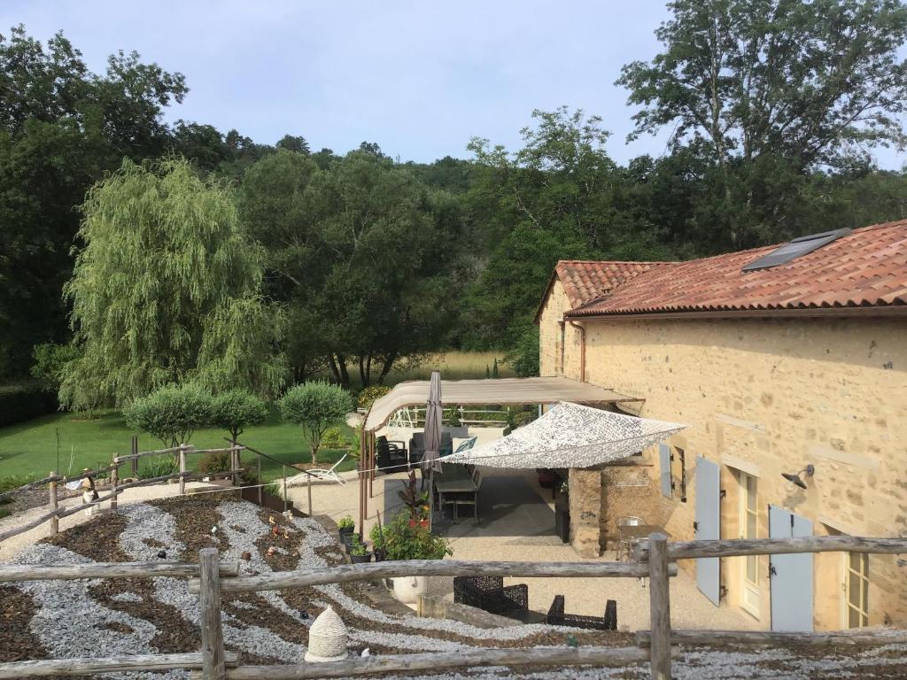 un edificio con una valla junto a un patio en Le Moulin de Mayence, en Plazac