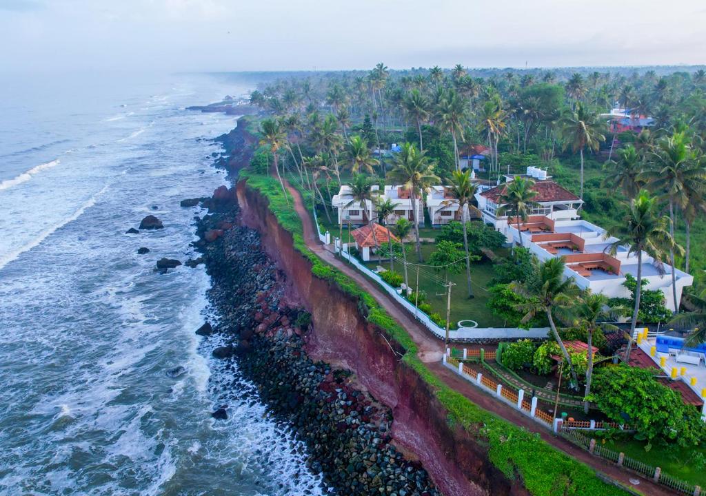 an aerial view of a resort next to the ocean at Solaris Varkala Beach Resort By VOYE HOMES in Varkala