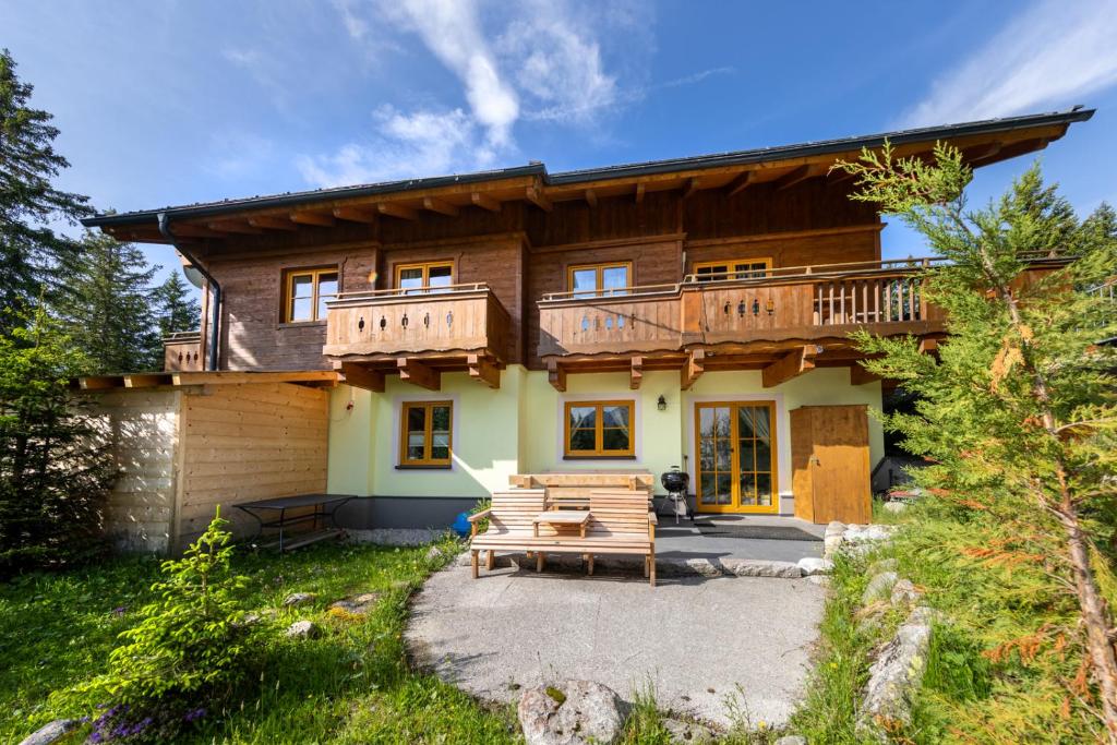a large wooden house with a patio in front of it at Appartement Juri Hochkrimml in Nothdorf