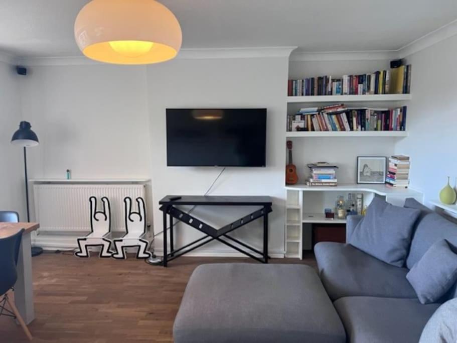 een woonkamer met een blauwe bank en een tv bij Big and bright 2 x double bedroom flat in Highgate in Londen