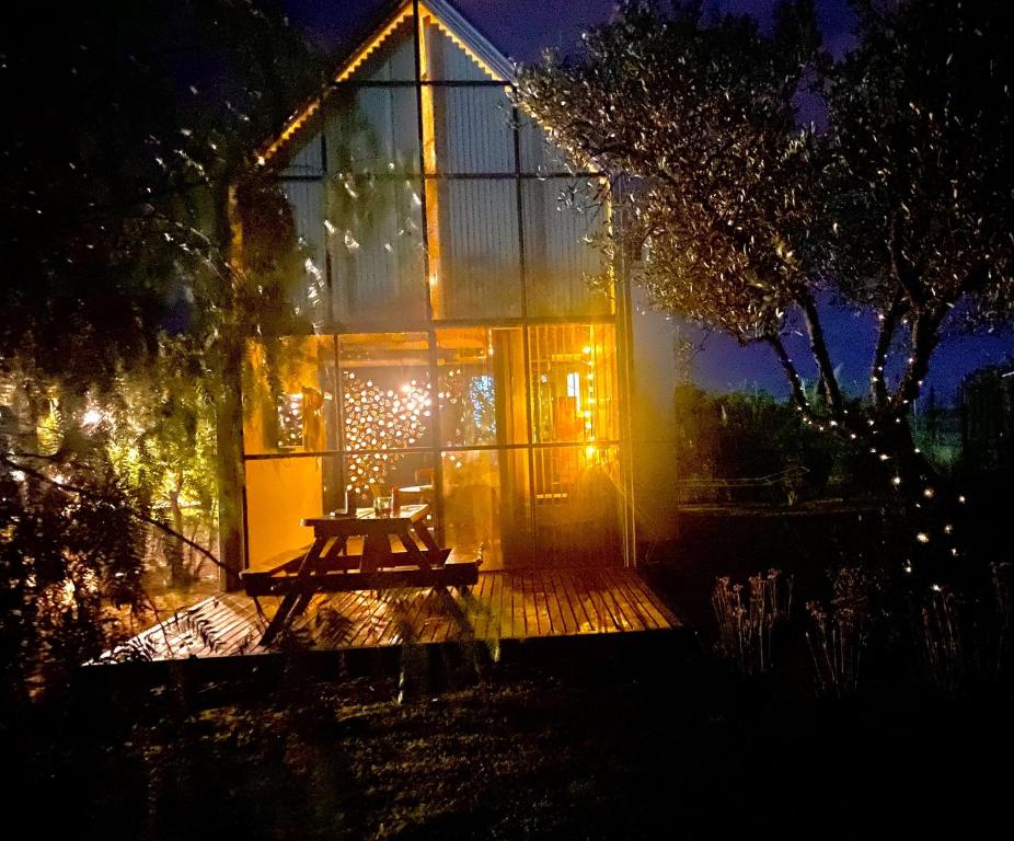 a glass house with a picnic table in front of it at night at Finca La Escondida San Rafael in San Rafael