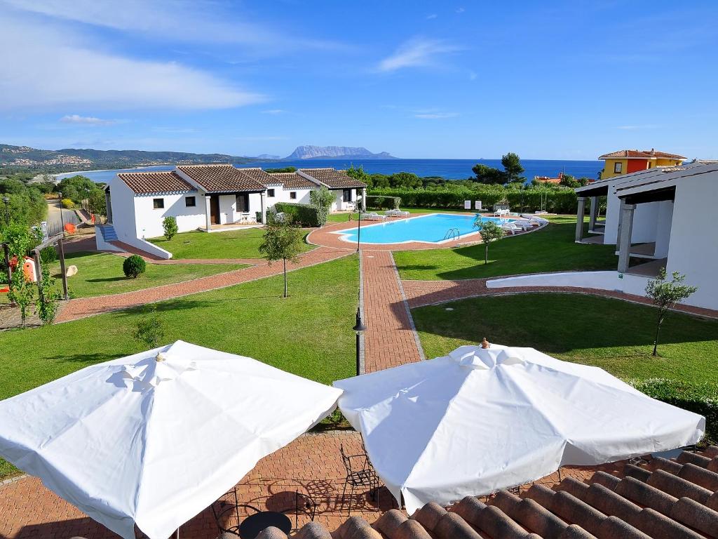 a white umbrella sitting on top of a lawn at Sa Prata Hotel & Resort in Budoni