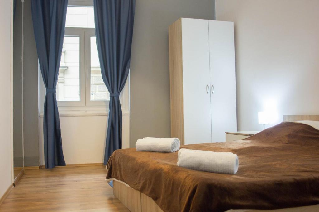 um quarto com uma cama com cortinas azuis e uma janela em City Center Apartment Dina 3 em Rijeka
