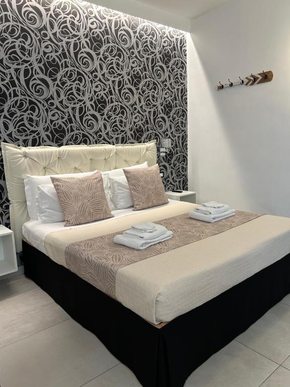 uma cama num quarto com uma parede a preto e branco em Alba rooms em La Spezia