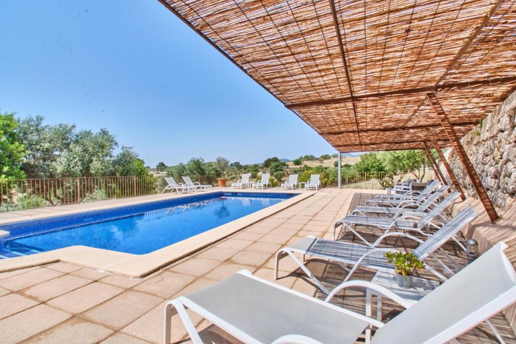 un grupo de sillas blancas y una piscina en Hotel Can Riera, en Moscari